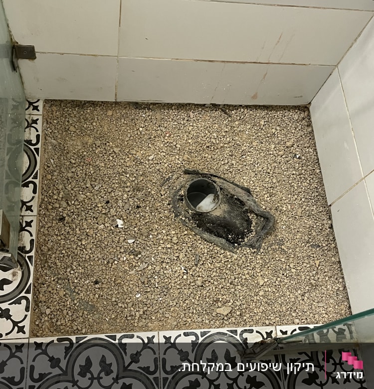 רצפה עם חצץ וצינור חשוף בשיפוץ חדר אמבטיה